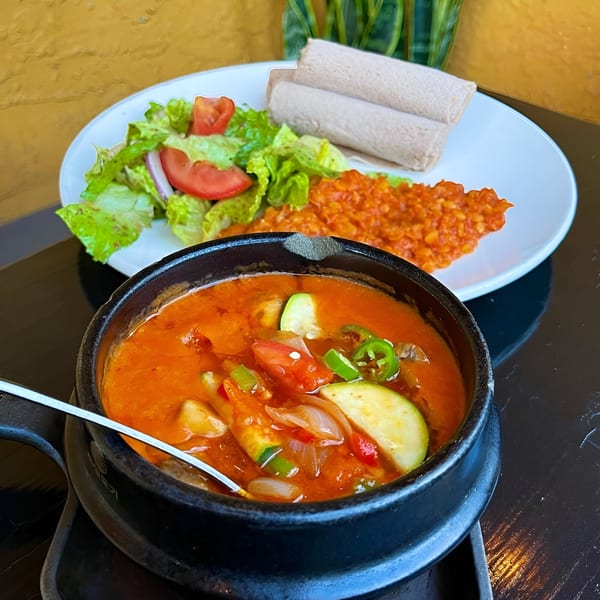 Ethiopian stew with zucchini and peppers, served with injera, salad, and red lentils.